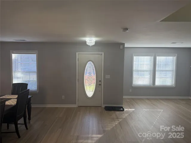 a view of a livingroom with wooden floor and a large window