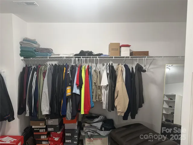 a view of walk in closet with clothes and shoes