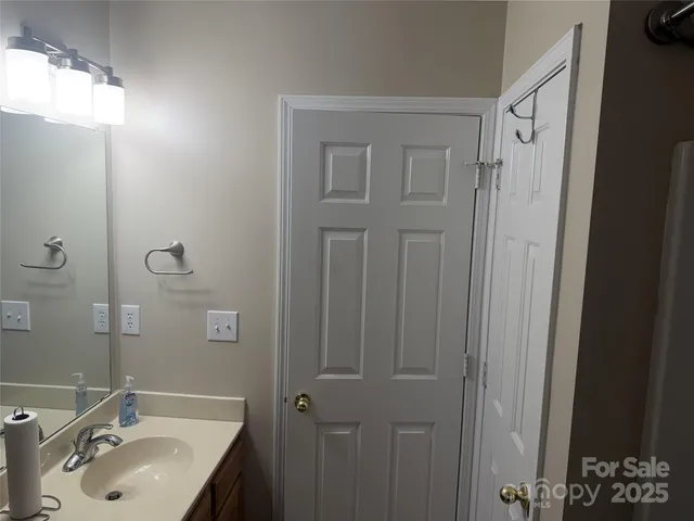 a bathroom with a sink vanity and shower