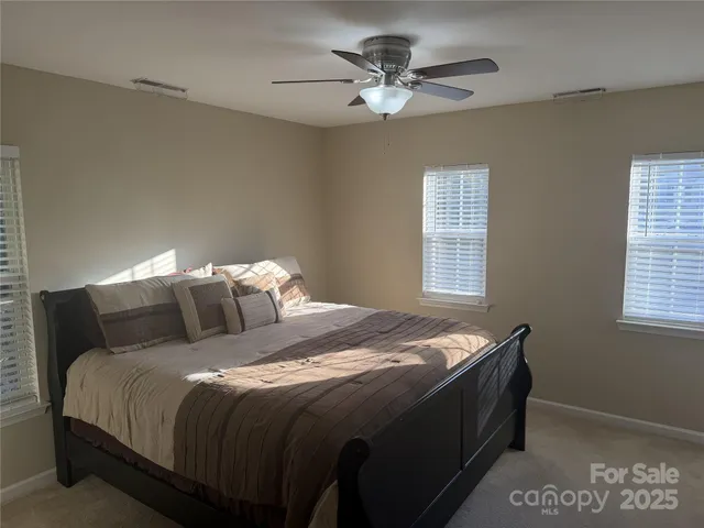 a bed sitting in a bedroom next to a window