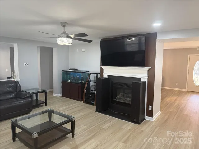a living room with furniture a flat screen tv and kitchen view