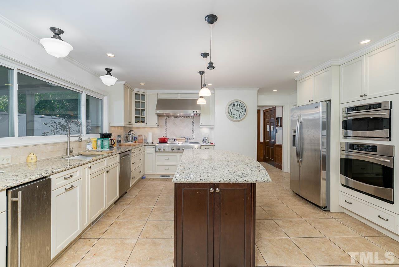 1221 Dixie Trail Raleigh, NC 27607 - Photo 12 of 26 a large kitchen with granite countertop a large kitchen island and a sink stainless steel appliances