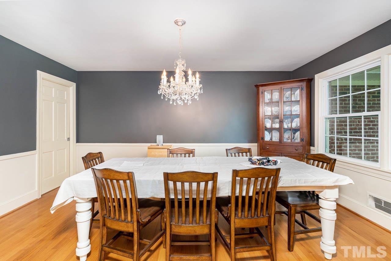 1221 Dixie Trail Raleigh, NC 27607 - Photo 7 of 26 a view of a dining room with furniture a chandelier and wooden floor