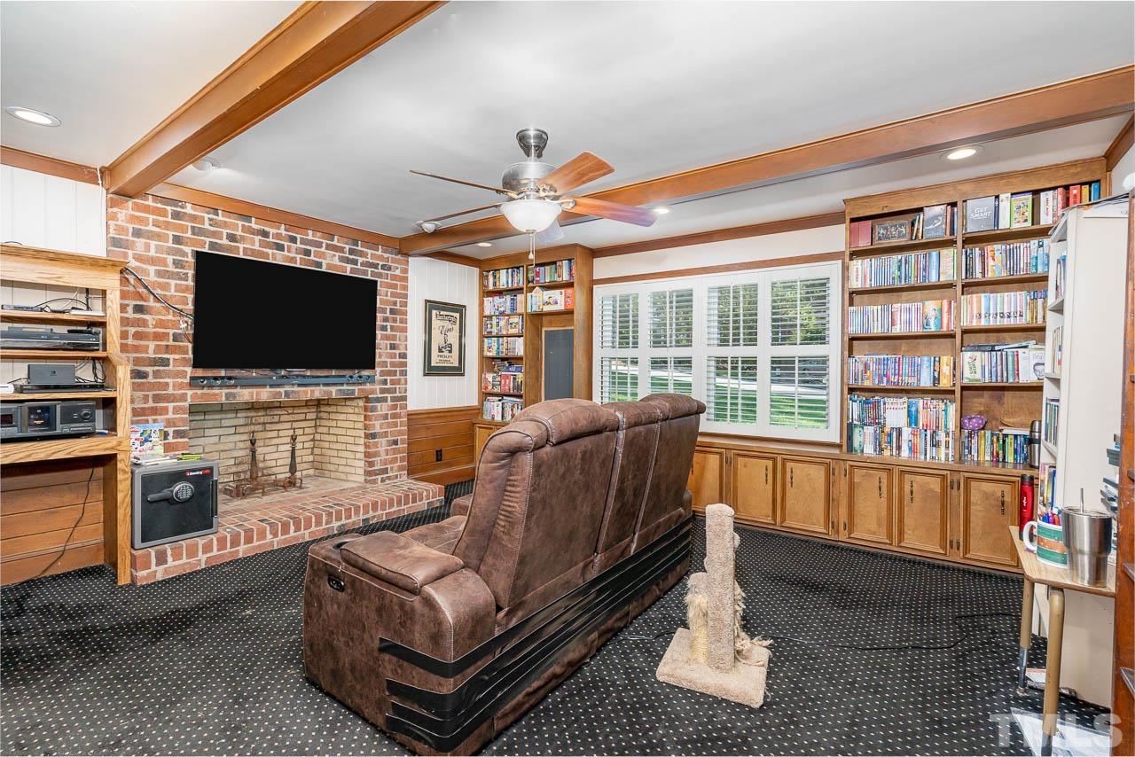1221 Dixie Trail Raleigh, NC 27607 - Photo 9 of 26 a living room with furniture a flat screen tv and a floor to ceiling window
