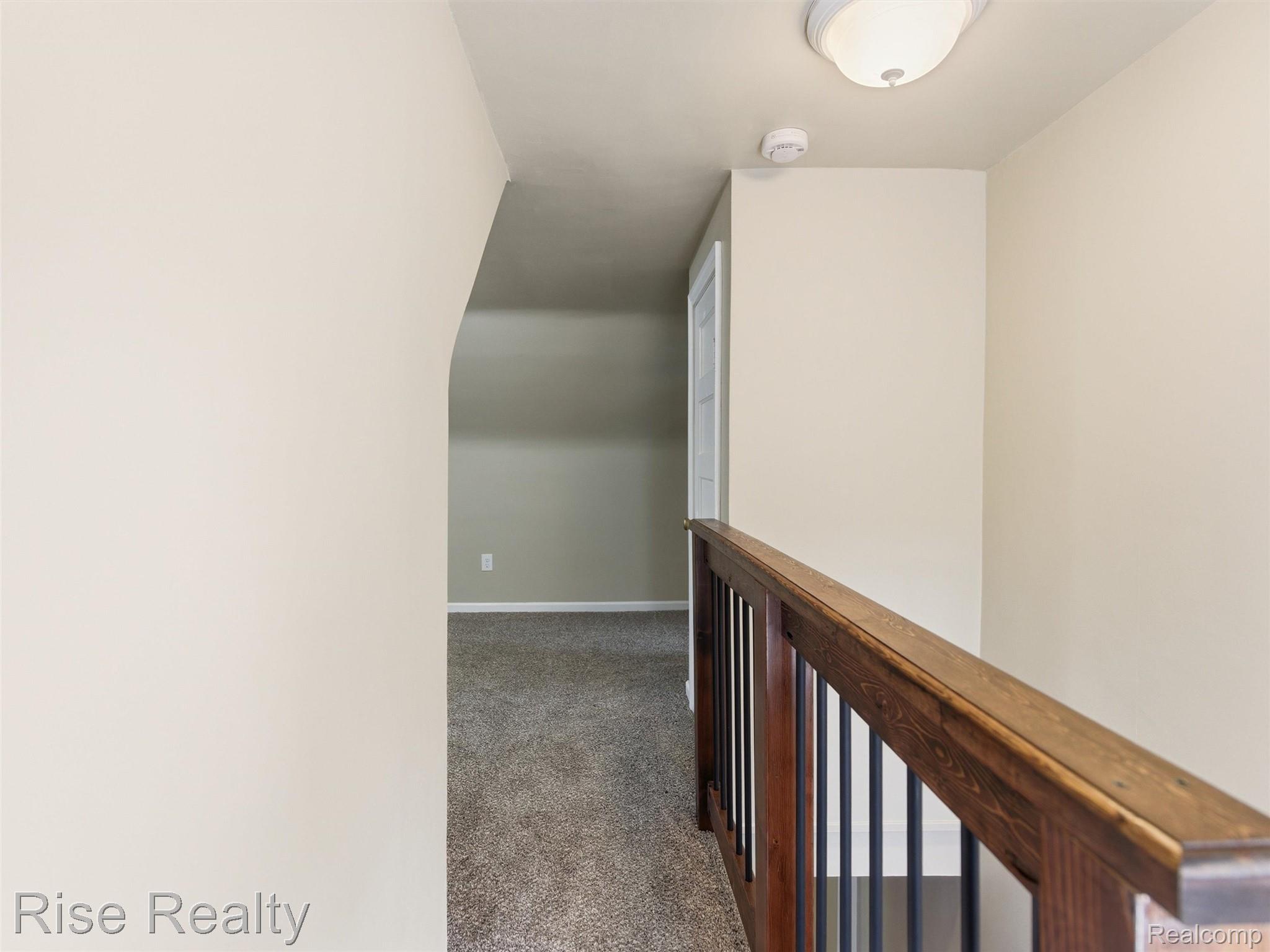 2449 North Genesee Road Burton, MI 48509 - Photo 22 of 40 Upper-level hallway with neutral wall paint and textured carpet flooring