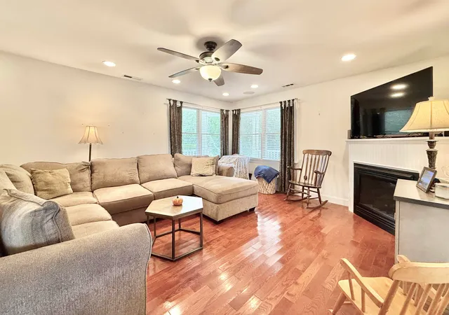 a living room with furniture a fireplace and a flat screen tv