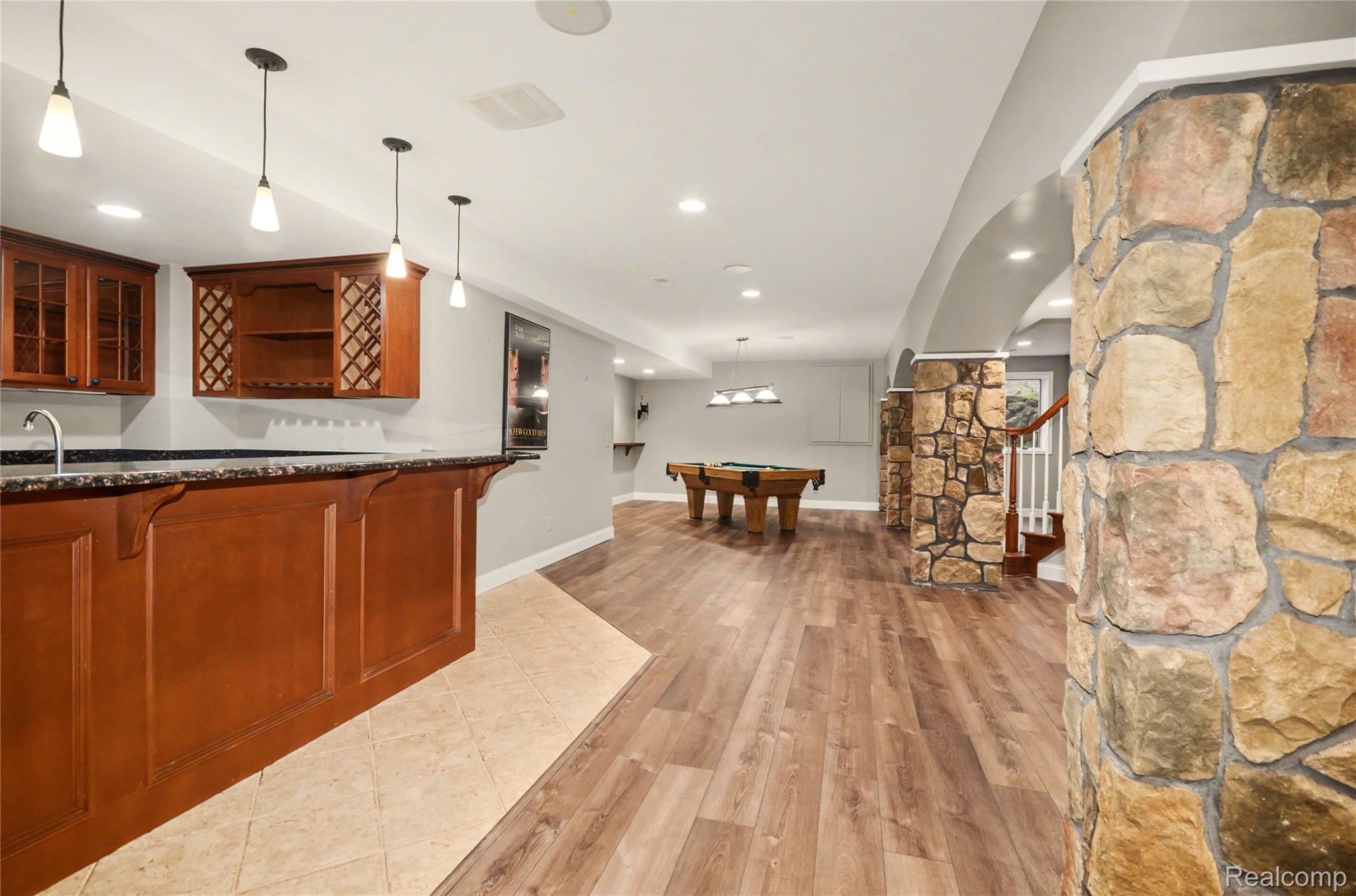 4179 St Andrews Street Howell, MI 48843 - Photo 45 of 75 Finished basement features LVP flooring, full bar, stone archways, and more.