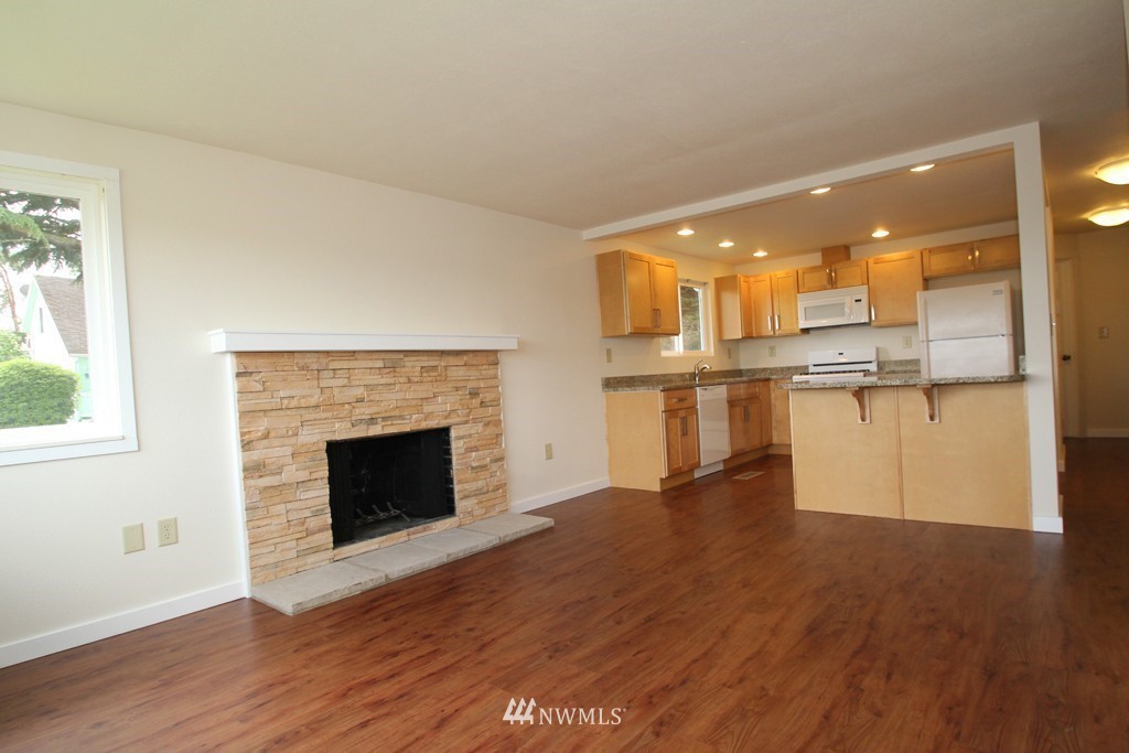 81 Southwest 2nd Street Renton, WA 98057 - Photo 5 of 22 a view of a kitchen with wooden floor and a fireplace