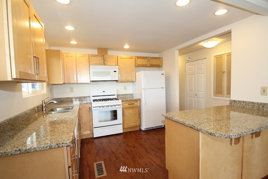 81 Southwest 2nd Street Renton, WA 98057 - Photo 6 of 22 a kitchen with a sink a stove a refrigerator and island