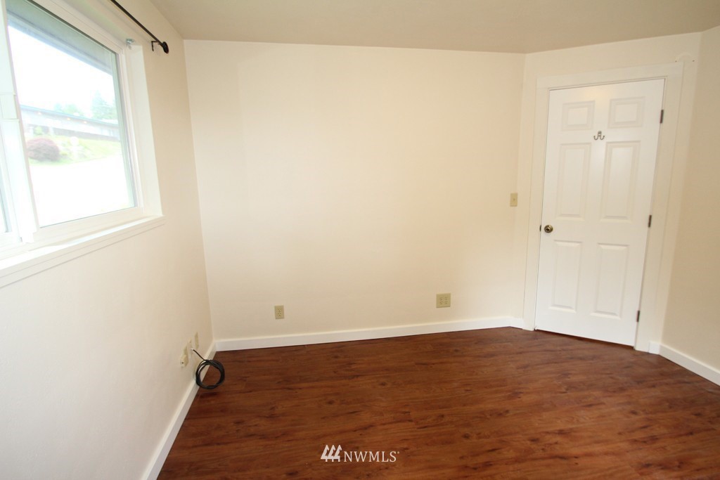 81 Southwest 2nd Street Renton, WA 98057 - Photo 7 of 22 an empty room with wooden floor and windows
