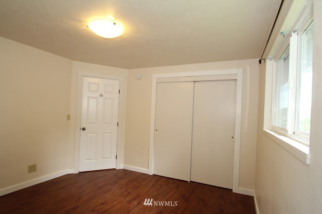 81 Southwest 2nd Street Renton, WA 98057 - Photo 8 of 22 a view of an empty room with wooden floor and a window