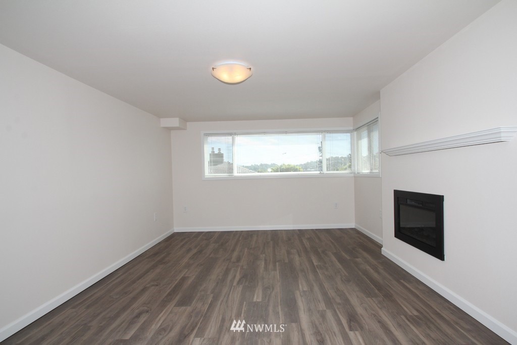 81 Southwest 2nd Street Renton, WA 98057 - Photo 9 of 22 an empty room with wooden floor and windows