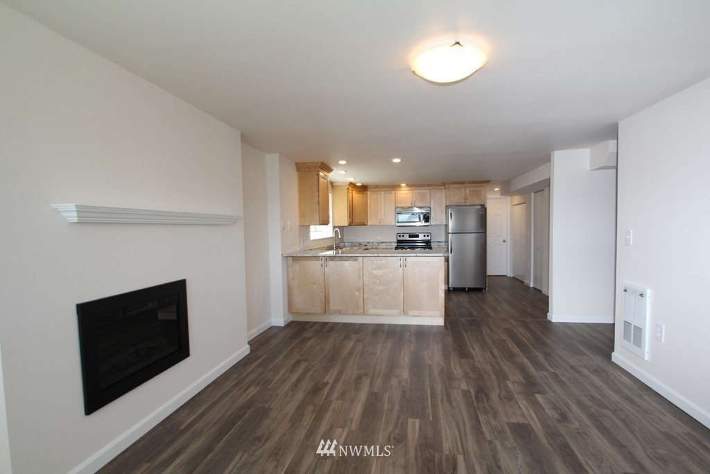 81 Southwest 2nd Street Renton, WA 98057 - Photo 10 of 22 a kitchen with wooden floors and white cabinets