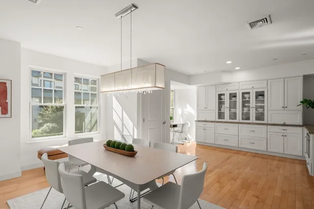 a kitchen with stainless steel appliances kitchen island granite countertop a table chairs and a refrigerator