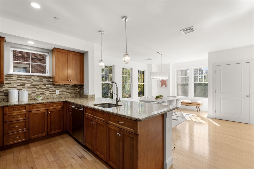 125 Crowninshield Road, Unit 125 Brookline, MA 02446 - Photo 13 of 22 a kitchen with counter top space sink and center island