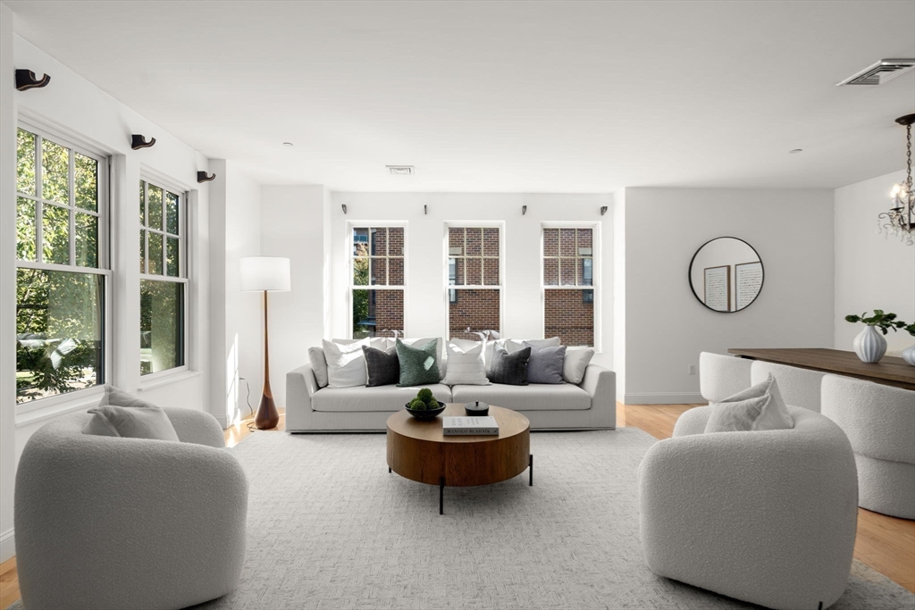 125 Crowninshield Road, Unit 125 Brookline, MA 02446 - Photo 2 of 22 a living room with furniture and a large window