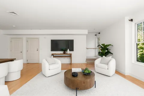 a living room with furniture a flat screen tv and a potted plant