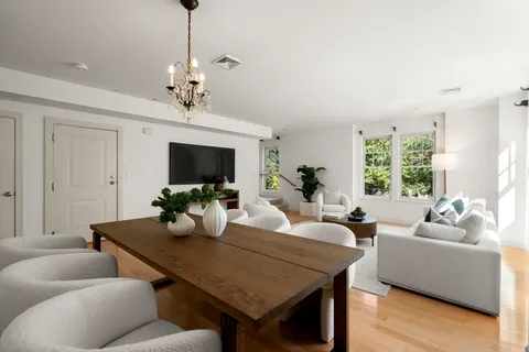 a living room with furniture a chandelier and a flat screen tv