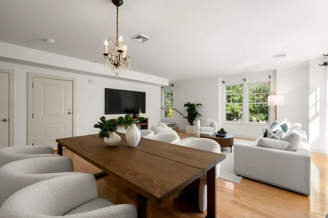 a living room with furniture a chandelier and a flat screen tv