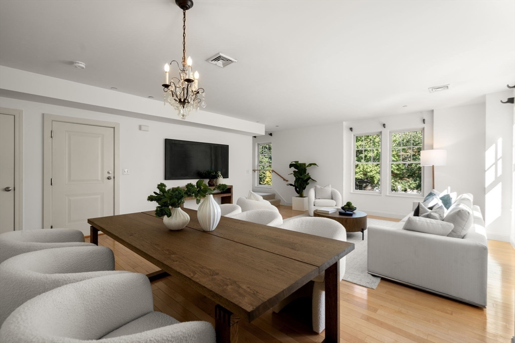 125 Crowninshield Road, Unit 125 Brookline, MA 02446 - Photo 8 of 22 a living room with furniture a chandelier and a flat screen tv