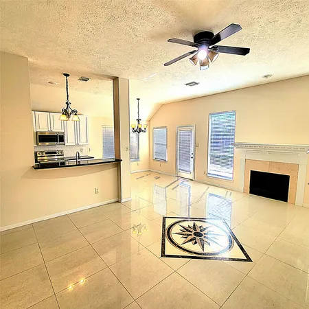 a living room with granite countertop furniture a fireplace and a chandelier