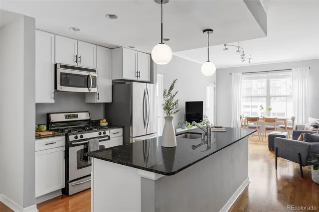 a kitchen with kitchen island a counter space a sink appliances and cabinets