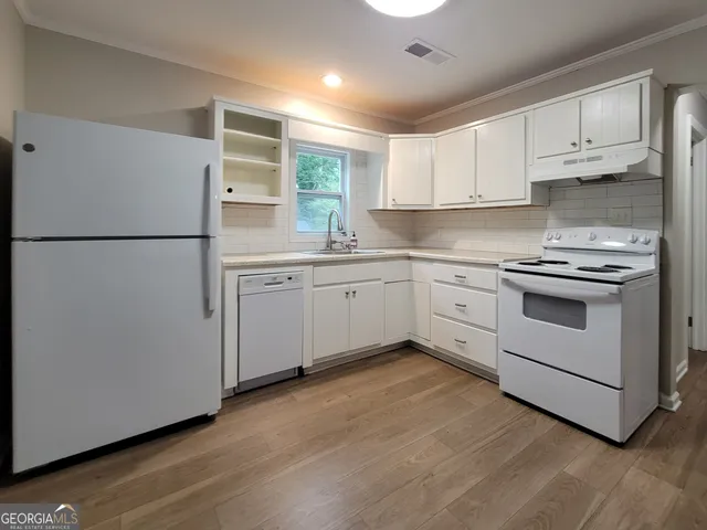 a kitchen with white cabinets and white appliances
