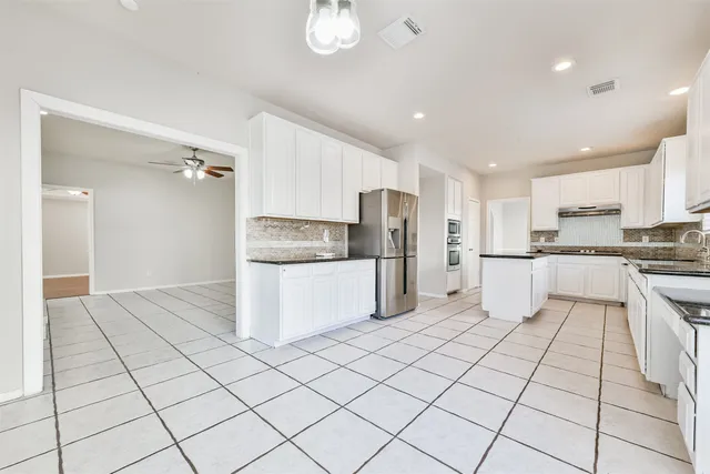 a kitchen with stainless steel appliances a refrigerator sink and cabinets