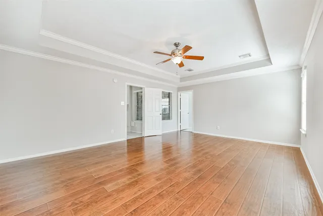 an empty room with wooden floor and windows