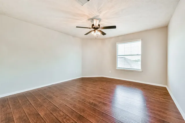 a view of an empty room with wooden floor