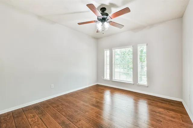 a view of an empty room with wooden floor