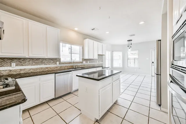 a kitchen with granite countertop a sink and a stove top oven