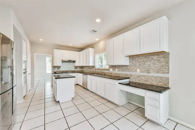 a kitchen with white cabinets appliances and a sink