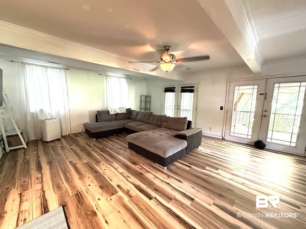 175 Lakeview Loop Daphne, AL 36526 - Photo 2 of 12 Living room featuring french doors, wood finished floors, healthy amount of natural light, ornamental molding, and a ceiling fan