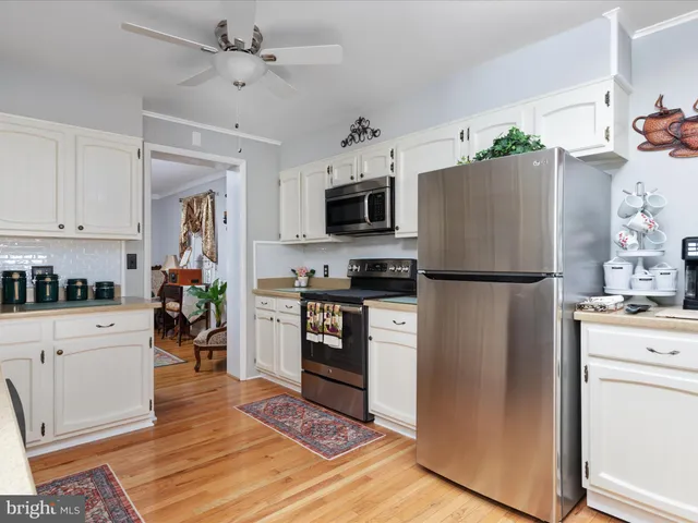 a kitchen with stainless steel appliances granite countertop a refrigerator stove microwave and cabinets