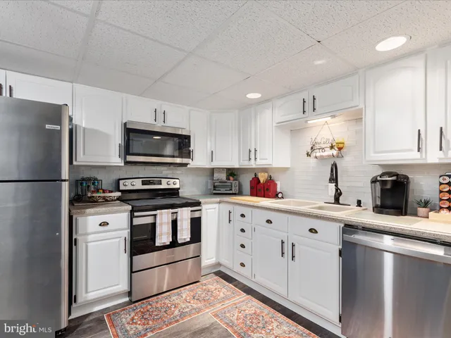 a kitchen with stainless steel appliances granite countertop a refrigerator sink and microwave