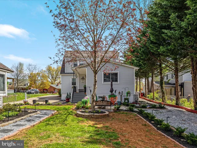 a front view of house with yard and trees in the background