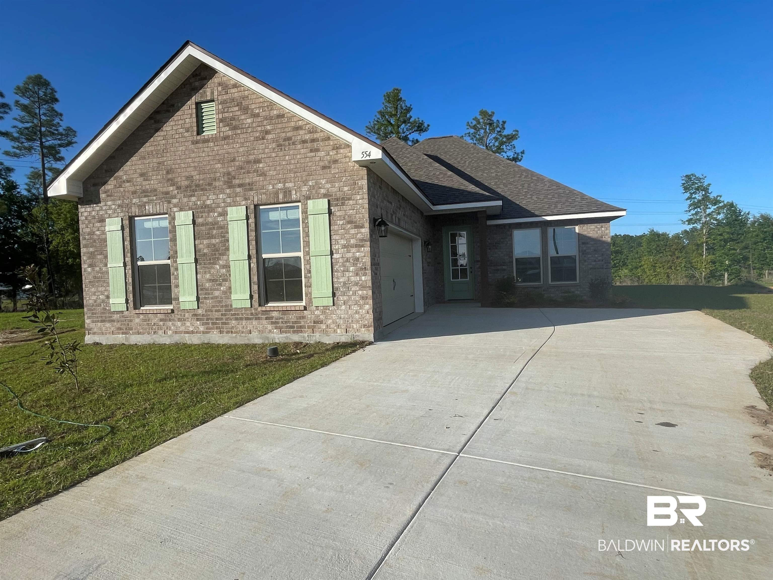 554 Sutton Lane Foley, AL 36535 - Photo 1 of 3 View of front of home featuring brick siding, an attached garage, driveway, and a front lawn