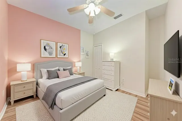 a bedroom with a bed and a flat tv screen on dresser