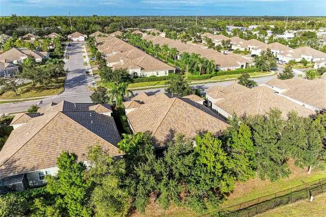 an aerial view of residential houses with outdoor space and trees