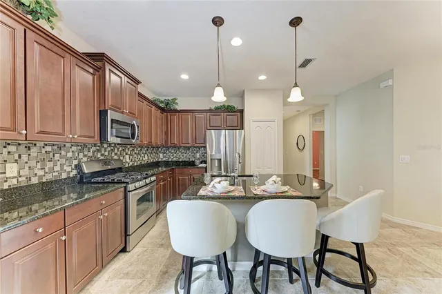 a kitchen with granite countertop a sink cabinets and stainless steel appliances