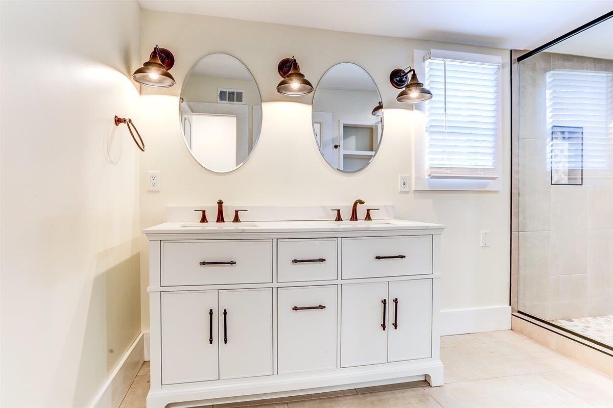 989 Bruce Street Memphis, TN 38104 - Photo 12 of 40 Bathroom featuring double vanity, a shower stall, and light tile patterned floors