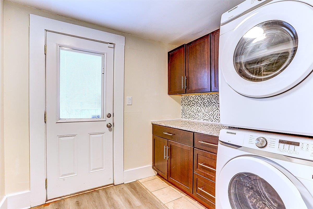 989 Bruce Street Memphis, TN 38104 - Photo 18 of 40 Laundry room featuring stacked washer / drying machine, cabinet space, and light wood finished floors
