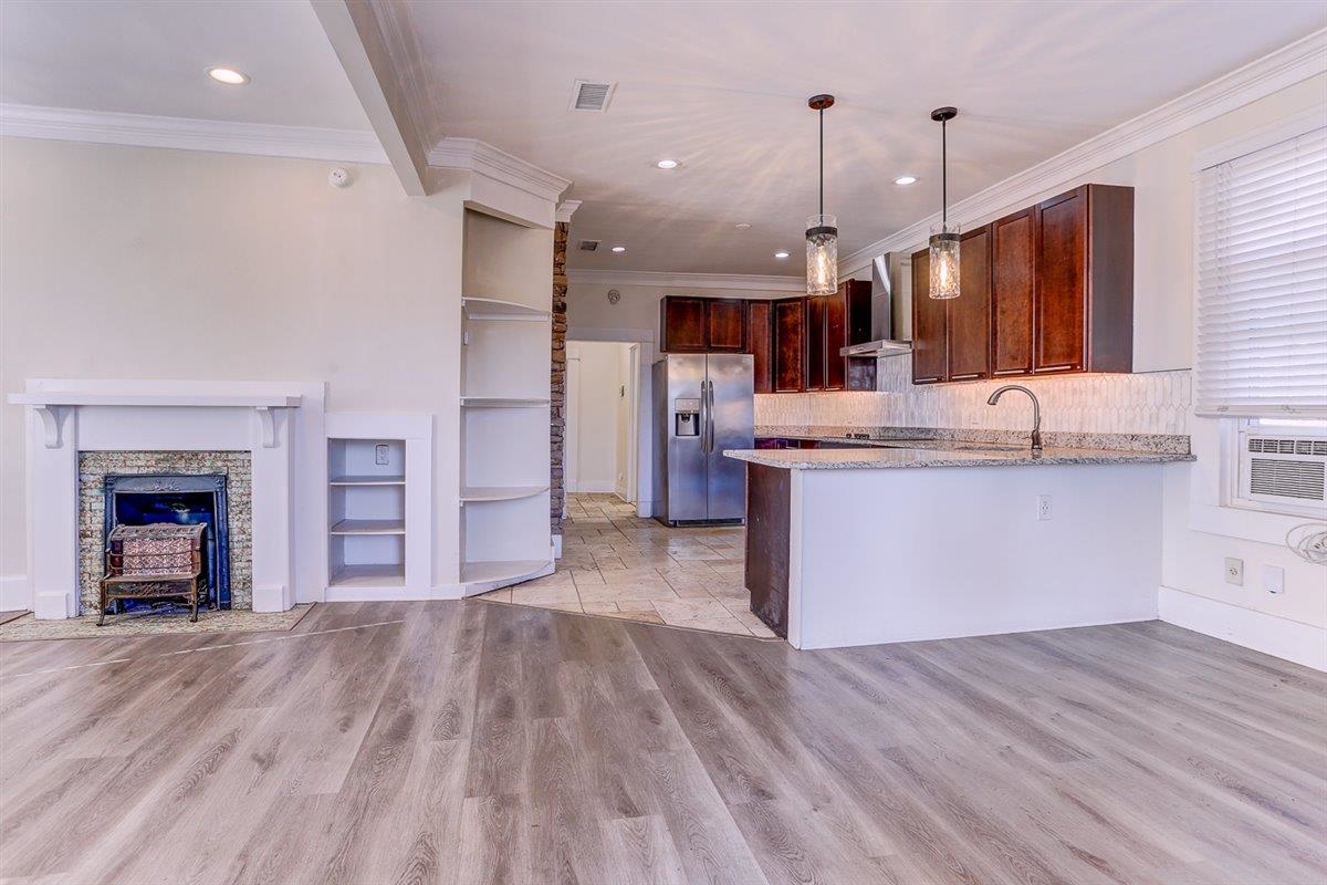 989 Bruce Street Memphis, TN 38104 - Photo 40 of 40 Kitchen featuring open floor plan, a peninsula, pendant lighting, dark brown cabinets, and light stone counters