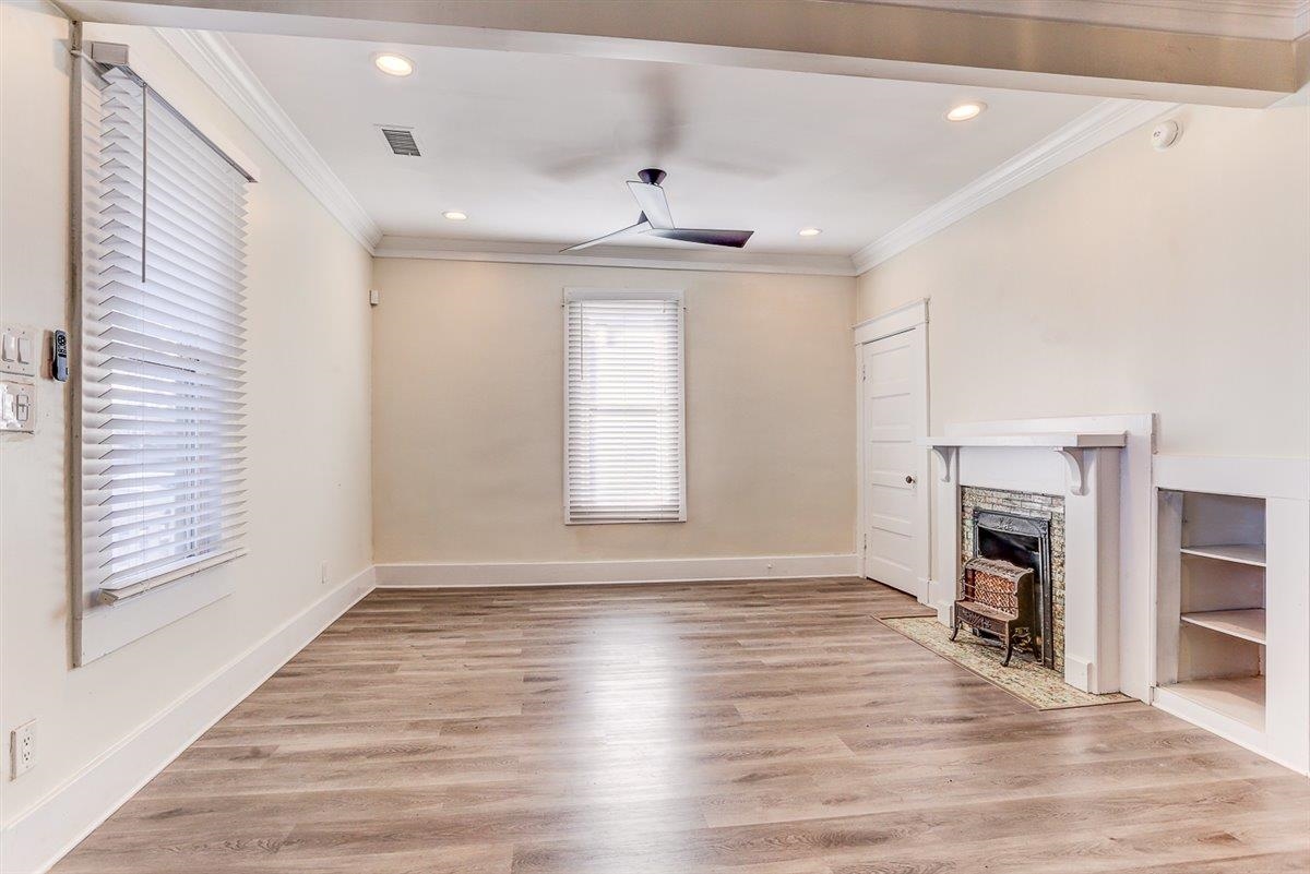 989 Bruce Street Memphis, TN 38104 - Photo 23 of 40 Unfurnished living room featuring light wood-type flooring, crown molding, recessed lighting, a fireplace with flush hearth, and ceiling fan