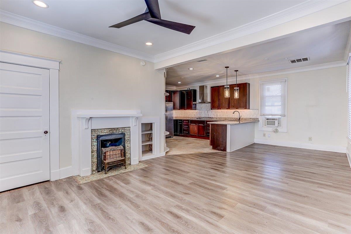 989 Bruce Street Memphis, TN 38104 - Photo 25 of 40 Unfurnished living room with a fireplace with flush hearth, recessed lighting, light wood finished floors, crown molding, and a ceiling fan