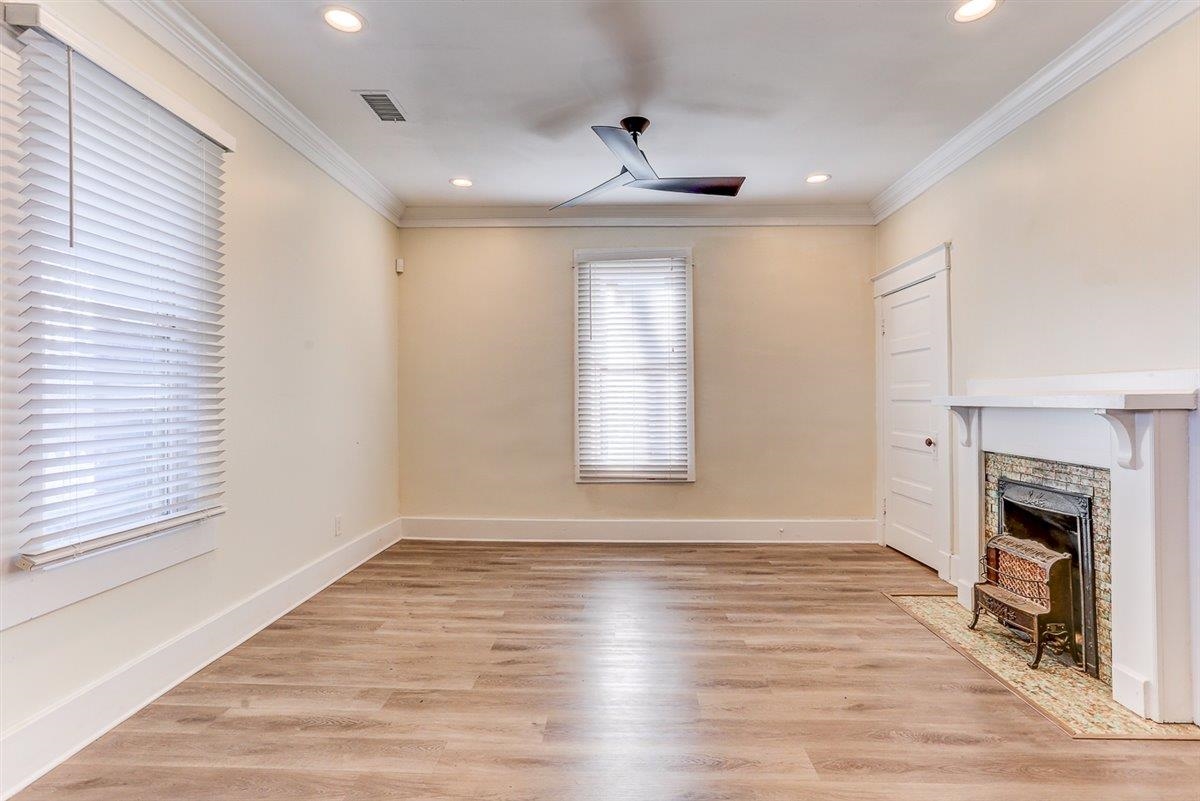 989 Bruce Street Memphis, TN 38104 - Photo 30 of 40 Unfurnished living room with light wood-style floors, a fireplace with flush hearth, ornamental molding, a ceiling fan, and recessed lighting