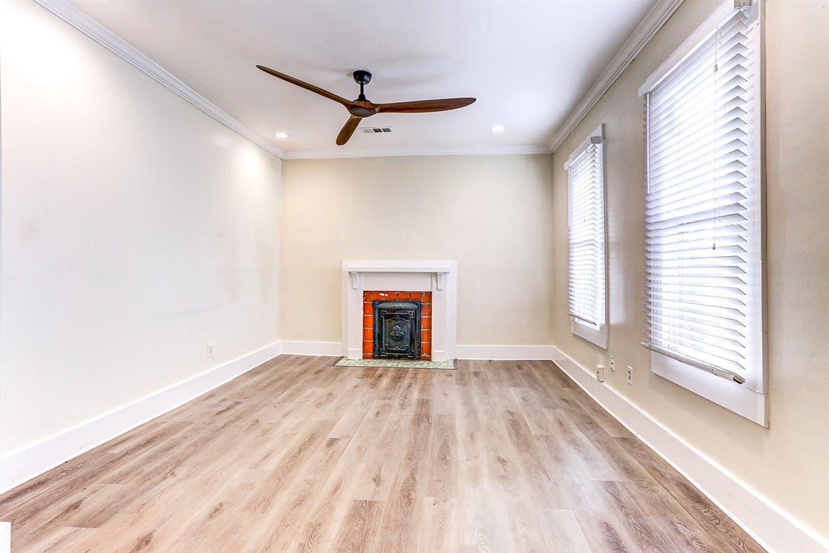 989 Bruce Street Memphis, TN 38104 - Photo 34 of 40 Unfurnished living room with ornamental molding, light wood-style floors, a ceiling fan, a tiled fireplace, and recessed lighting