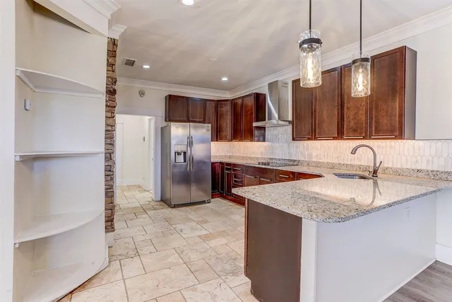 a kitchen with stainless steel appliances granite countertop a sink refrigerator and cabinets