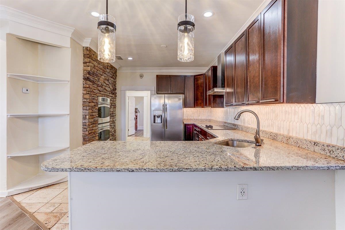 989 Bruce Street Memphis, TN 38104 - Photo 7 of 40 a kitchen with stainless steel appliances granite countertop a sink refrigerator and cabinets